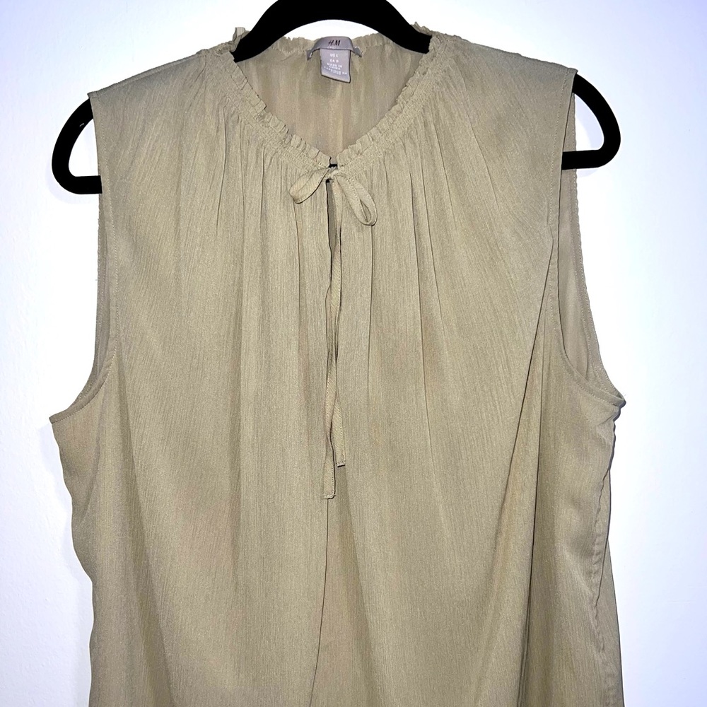 H&M taupe colored flowy top with peep hole tie at neck.